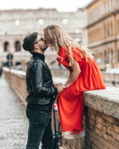 couple kissing on stone wall